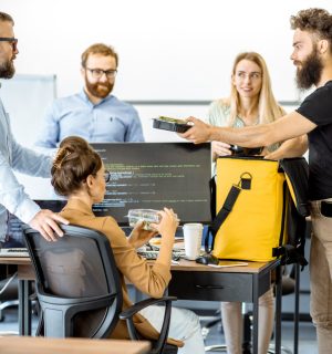 Courier delivering fresh lunches with yellow thermal bag for office workers. Concept of food delivery to employees in the office